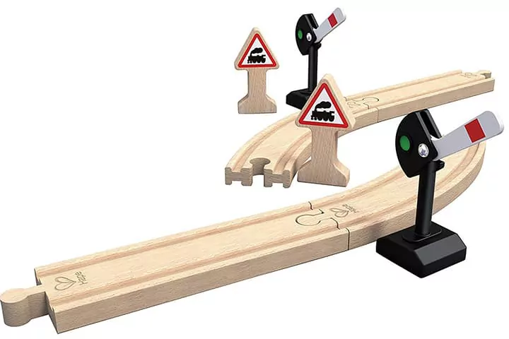 Hape-Schienen mit Herz-Logo, zusammengesteckt mit Bahnübergang und Warnschildern